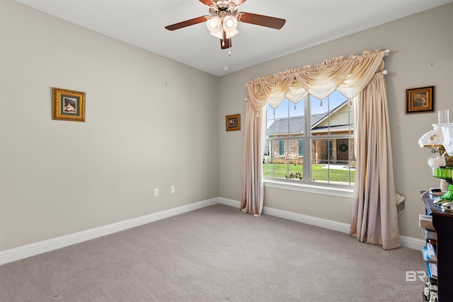 spare room featuring baseboards, light carpet, and a ceiling fan