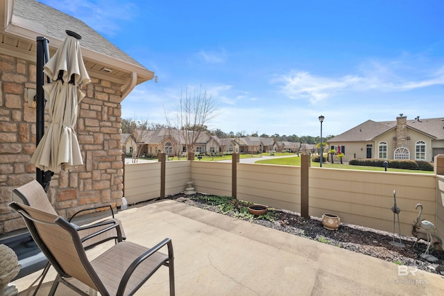 view of patio / terrace with a residential view and fence