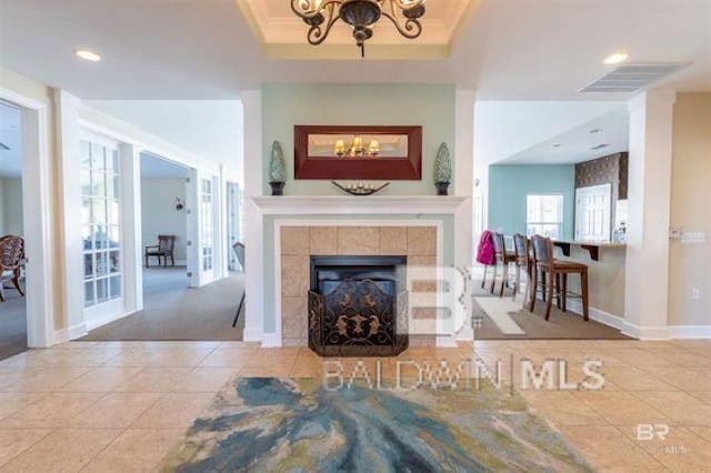 living room with tile patterned floors, baseboards, a notable chandelier, and crown molding