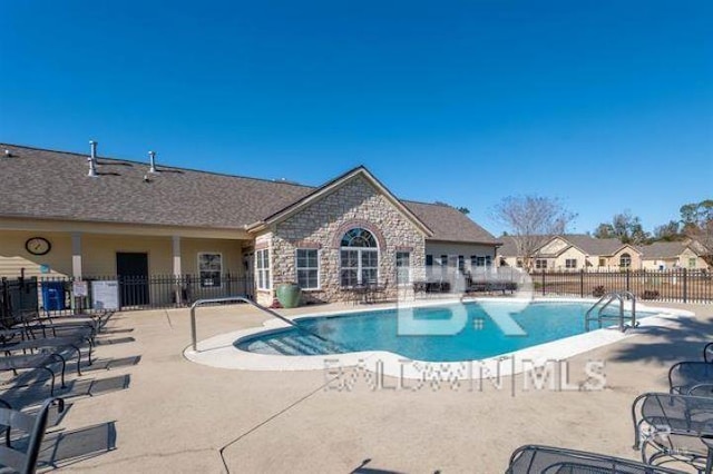 pool with a patio area and fence