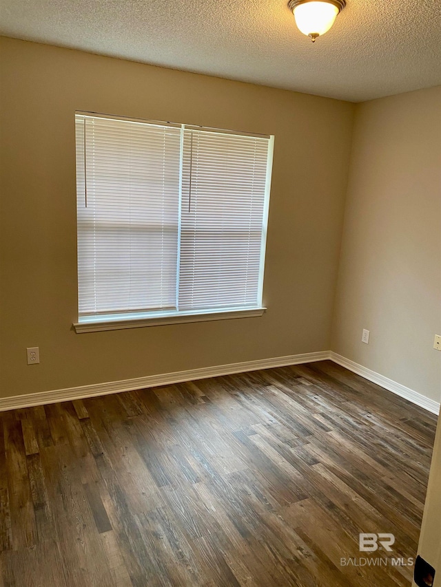 unfurnished room with a textured ceiling and dark wood-type flooring