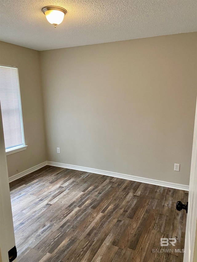 unfurnished room with a textured ceiling and dark hardwood / wood-style floors