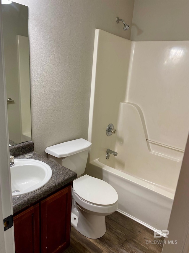 full bathroom featuring hardwood / wood-style flooring, vanity, toilet, and tub / shower combination