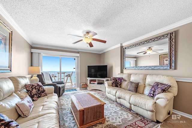 living room featuring a textured ceiling, ceiling fan, ornamental molding, and baseboards