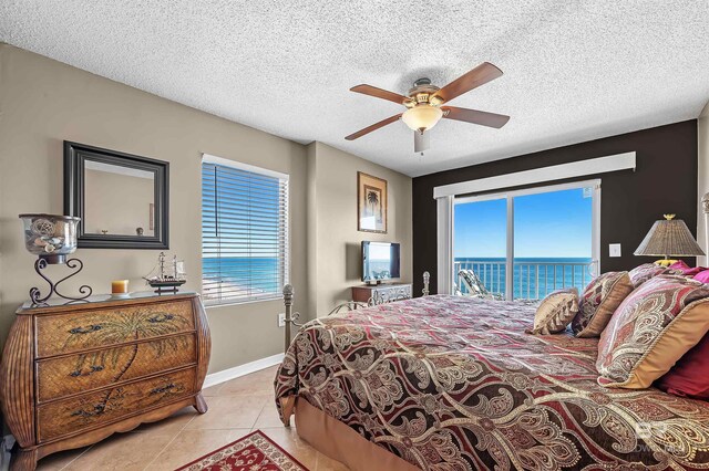 bedroom with baseboards, ceiling fan, access to exterior, a textured ceiling, and light tile patterned flooring