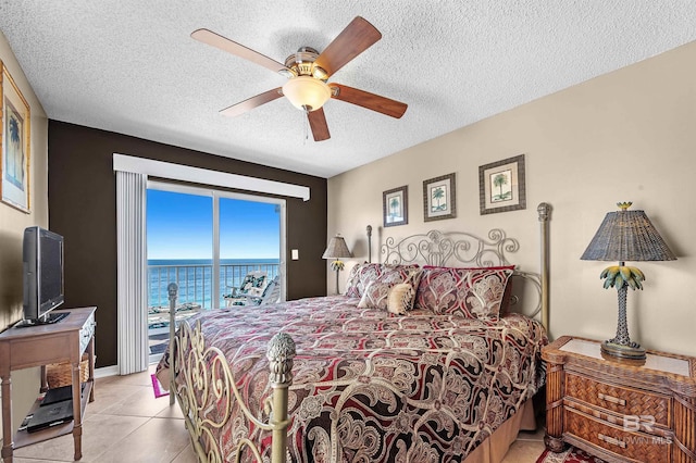 bedroom with ceiling fan, access to outside, light tile patterned floors, and a textured ceiling