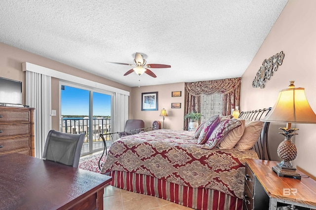 bedroom featuring access to exterior, light tile patterned flooring, ceiling fan, and a textured ceiling