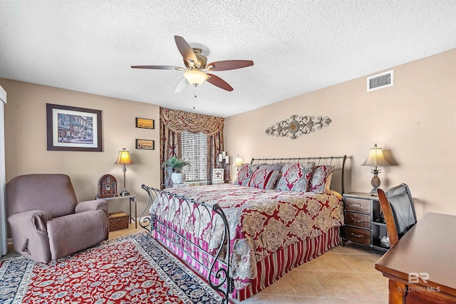 bedroom featuring a ceiling fan, visible vents, a textured ceiling, and light tile patterned flooring