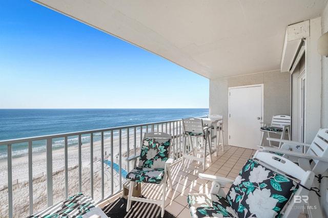 balcony featuring a water view and a beach view