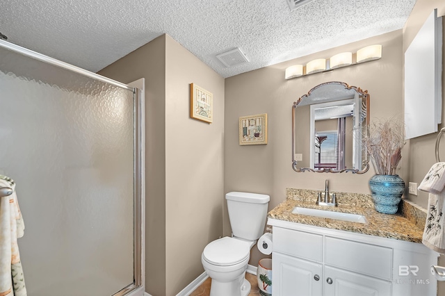 full bath featuring a textured ceiling, vanity, a shower stall, and visible vents