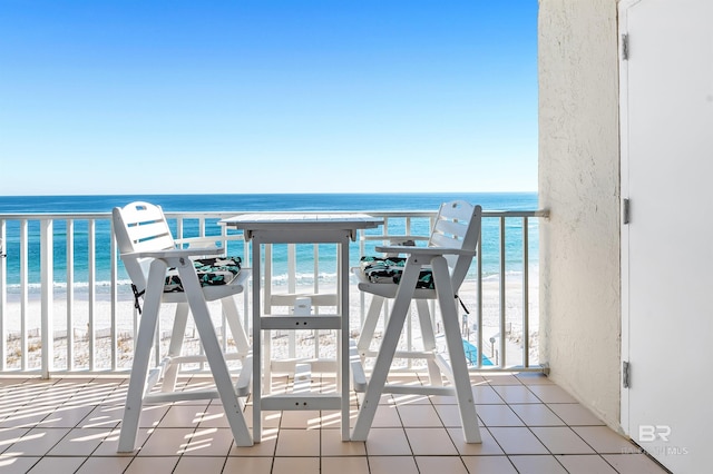 balcony featuring a water view and a view of the beach