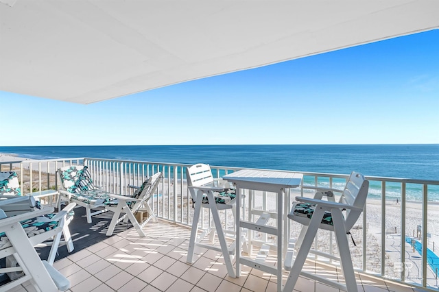 balcony featuring a water view and a beach view