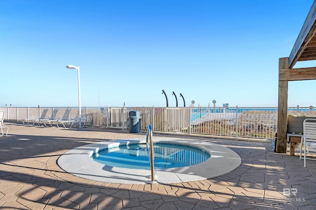 view of swimming pool with a patio area, a water view, fence, and a hot tub