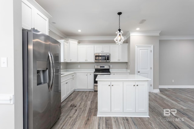 kitchen featuring pendant lighting, appliances with stainless steel finishes, light hardwood / wood-style floors, and white cabinetry