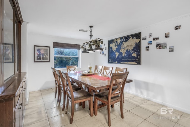 tiled dining room featuring ornamental molding and a notable chandelier