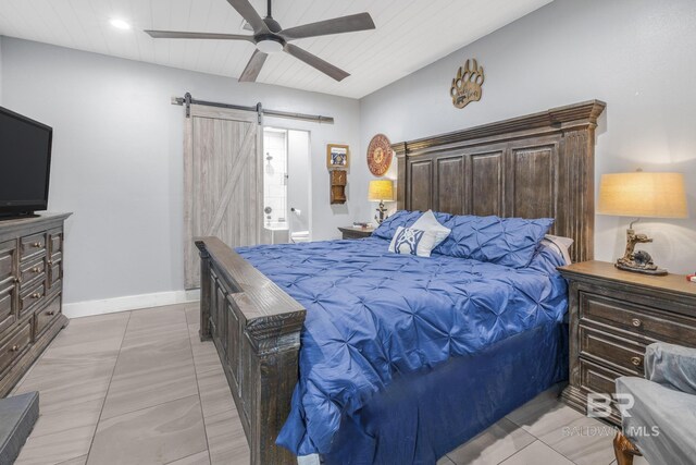 tiled bedroom with a barn door and ceiling fan