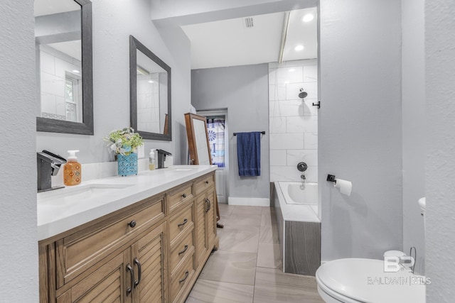 full bathroom with toilet, tiled shower / bath, vaulted ceiling, vanity, and tile patterned flooring