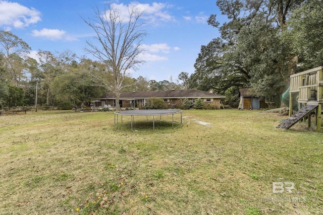 view of yard with a storage shed and a trampoline