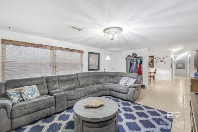 tiled living room featuring a chandelier