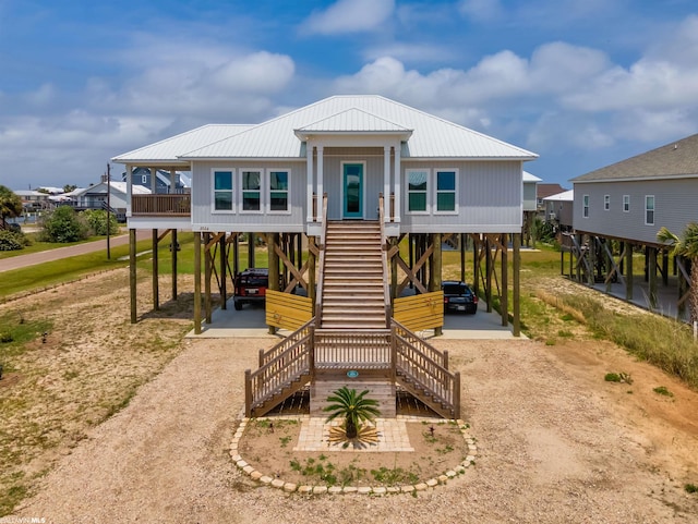 coastal inspired home featuring a carport and a front lawn