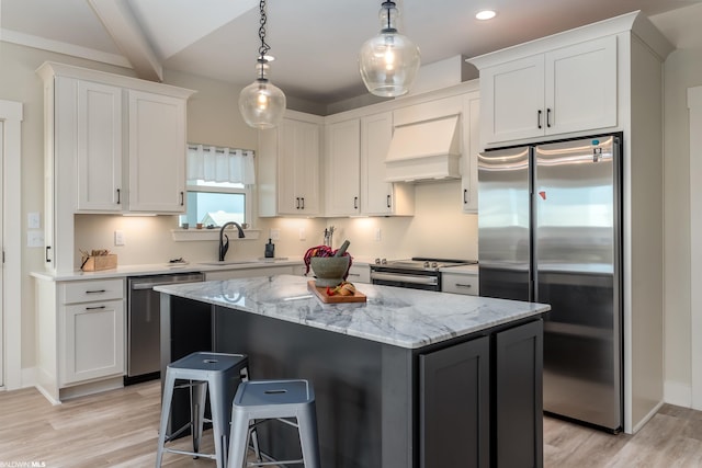 kitchen featuring light hardwood / wood-style floors, a kitchen island, stainless steel appliances, and premium range hood