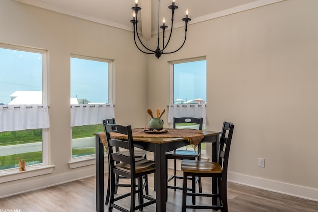 dining room featuring ornamental molding, a chandelier, hardwood / wood-style flooring, and a healthy amount of sunlight