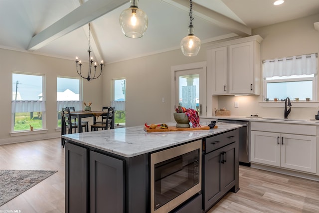 kitchen featuring vaulted ceiling with beams, built in microwave, light hardwood / wood-style flooring, white cabinetry, and hanging light fixtures