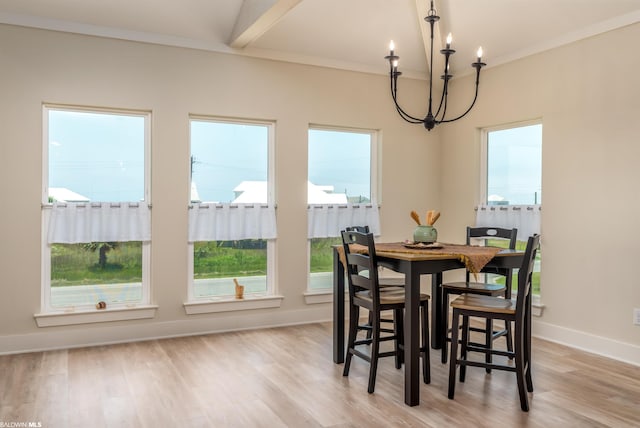 dining area with an inviting chandelier, ornamental molding, and light wood-type flooring