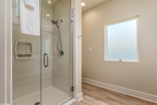 bathroom with hardwood / wood-style floors and an enclosed shower