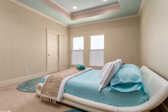 bedroom with crown molding, light carpet, and a tray ceiling