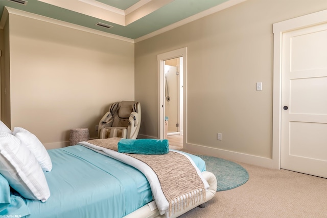 bedroom featuring crown molding, light colored carpet, and a tray ceiling