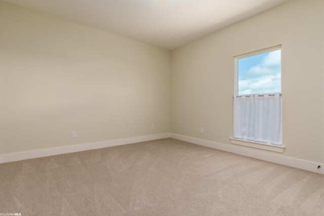 unfurnished room featuring light carpet