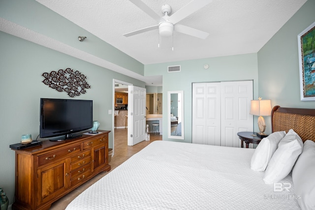 bedroom featuring a closet, tile patterned flooring, a textured ceiling, and a ceiling fan