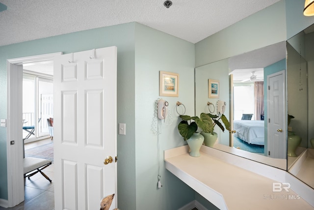 ensuite bathroom with tile patterned flooring, a textured ceiling, and toilet