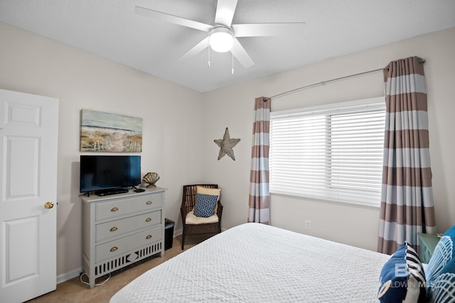 bedroom with a ceiling fan and baseboards