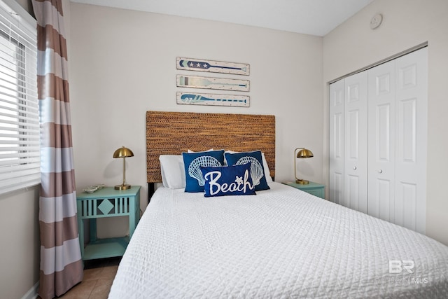 tiled bedroom featuring a closet and baseboards