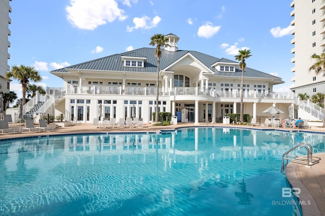 community pool featuring stairway and a patio area