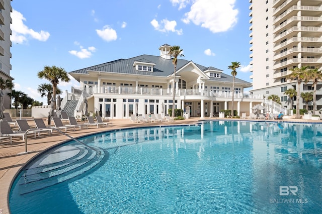 community pool with stairs and a patio area