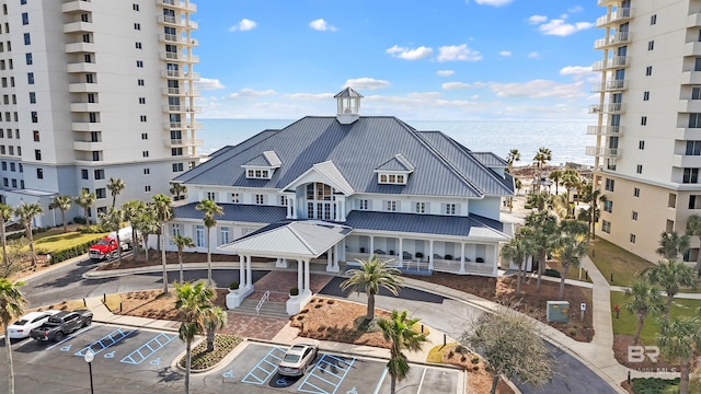 view of building exterior with uncovered parking and a water view