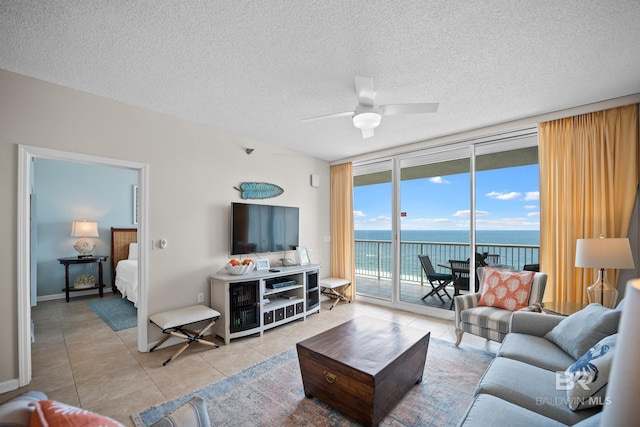 living room featuring floor to ceiling windows, light tile patterned floors, ceiling fan, and a textured ceiling