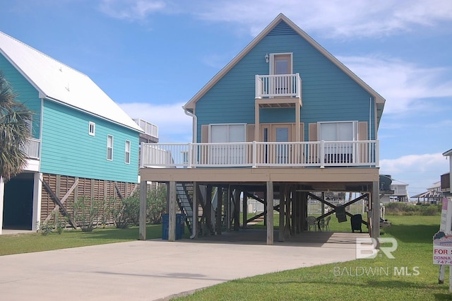 view of front of house featuring a front yard, a carport, a balcony, and covered porch