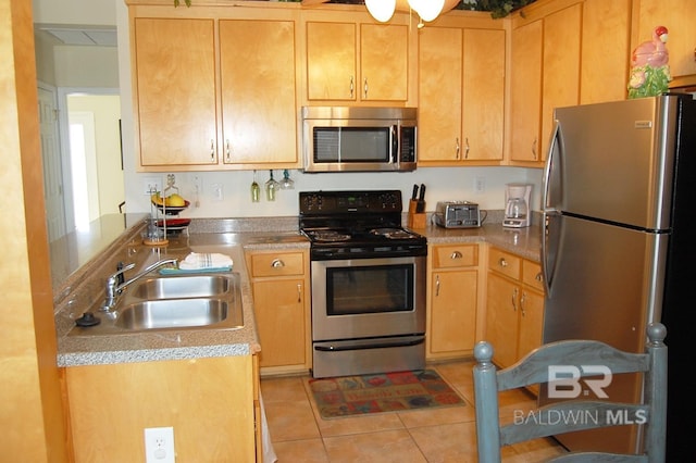 kitchen with appliances with stainless steel finishes, sink, and light tile patterned floors