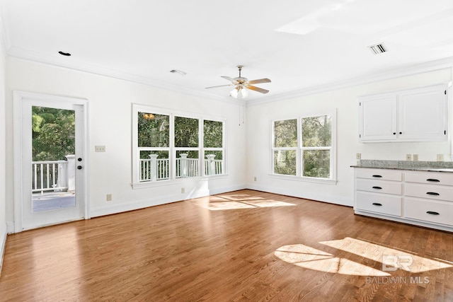 unfurnished living room featuring ceiling fan, hardwood / wood-style floors, and ornamental molding