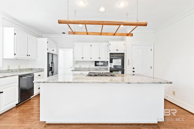 kitchen with black appliances, a center island, and white cabinets