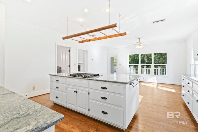 kitchen featuring white cabinetry, a center island, light wood-type flooring, and stainless steel gas stovetop