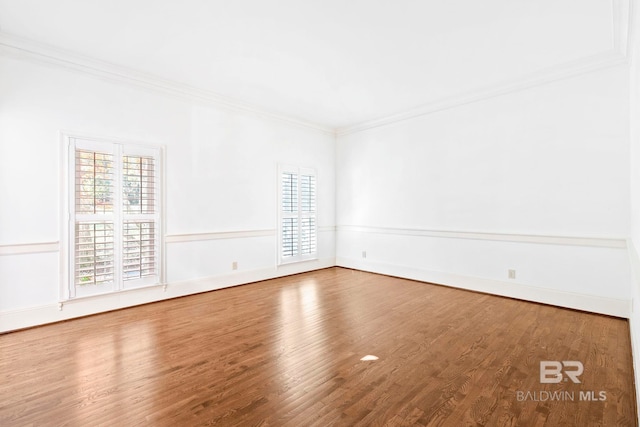 empty room with wood-type flooring and ornamental molding