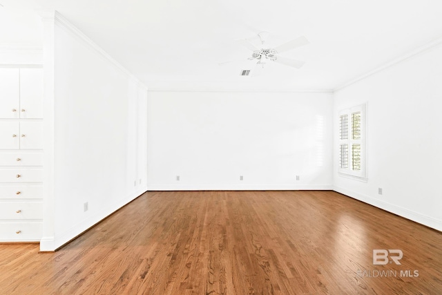 spare room featuring wood-type flooring and ornamental molding