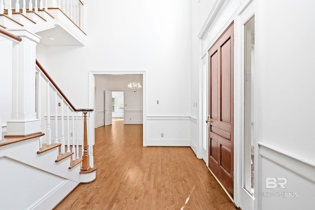 entryway featuring crown molding, a chandelier, and wood-type flooring