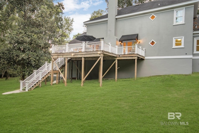 rear view of property with a lawn and a wooden deck