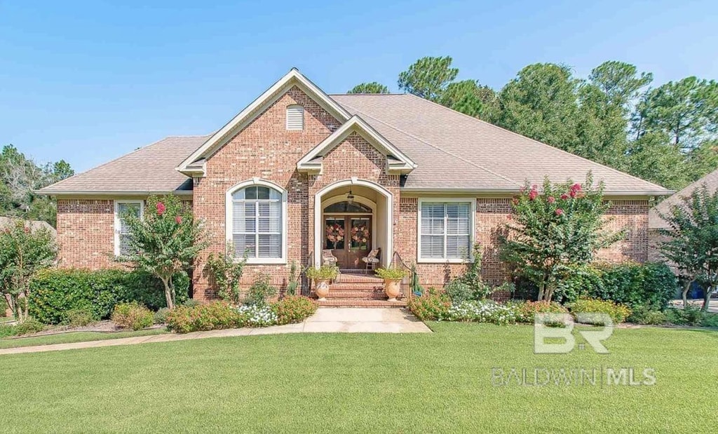 30208 Dolive Rdg, Daphne, AL 36527 - view of front of home featuring brick siding, a front lawn, french doors, and roof with shingles